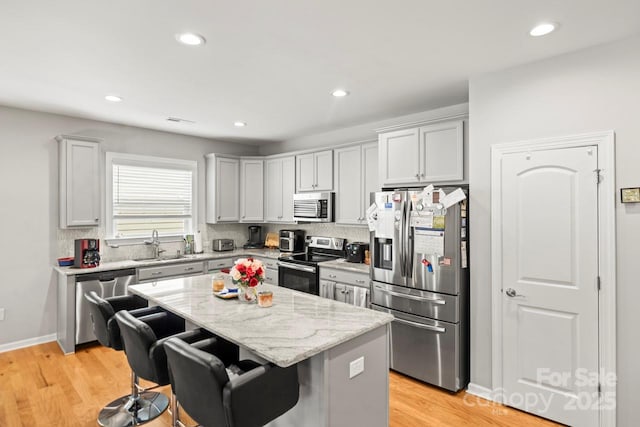 219 Broadleaf Dr, Denver, NC 28037 - kitchen featuring appliances with stainless steel finishes, a sink, a center island, a kitchen bar, and backsplash