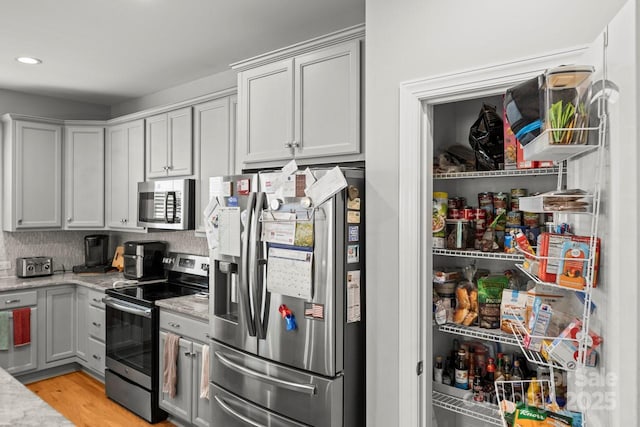 219 Broadleaf Dr, Denver, NC 28037 - kitchen with appliances with stainless steel finishes, light wood-style flooring, light stone counters, recessed lighting, and decorative backsplash