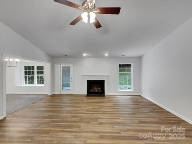 12307 Poplar Forest Dr, Charlotte, NC 28278 - unfurnished living room featuring recessed lighting, baseboards, wood finished floors, a fireplace with flush hearth, and a chandelier