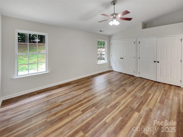 12307 Poplar Forest Dr, Charlotte, NC 28278 - unfurnished bedroom featuring wood finished floors, vaulted ceiling, two closets, baseboards, and ceiling fan