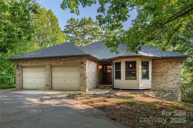 1227 Brush Creek Cir, Fairview, NC 28730 - view of front of property featuring brick siding, a garage, driveway, and a shingled roof