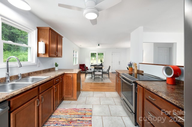 205 Cowan Cove Rd, Asheville, NC 28806 - kitchen with appliances with stainless steel finishes, a sink, brown cabinetry, light tile patterned flooring, and a ceiling fan