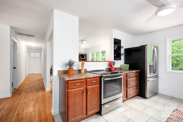 205 Cowan Cove Rd, Asheville, NC 28806 - kitchen with stainless steel appliances, a ceiling fan, brown cabinets, and healthy amount of natural light