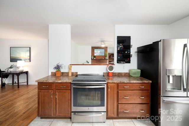 205 Cowan Cove Rd, Asheville, NC 28806 - kitchen featuring appliances with stainless steel finishes, brown cabinetry, ceiling fan, and dark countertops