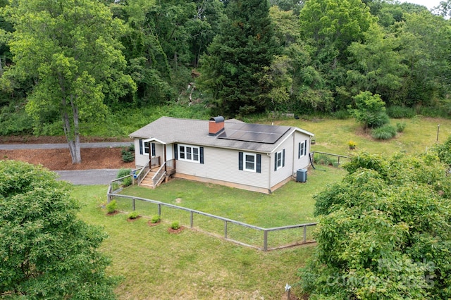 205 Cowan Cove Rd, Asheville, NC 28806 - view of front facade with solar panels, cooling unit, a chimney, and a wooded view