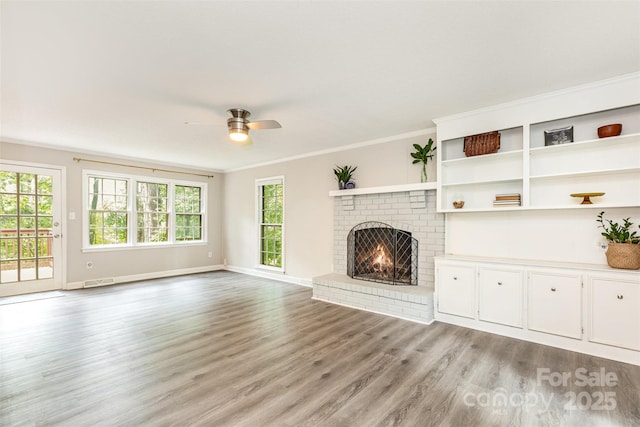 14027 Hackamore Dr, Matthews, NC 28105 - unfurnished living room with crown molding, light wood-style flooring, a brick fireplace, and a ceiling fan