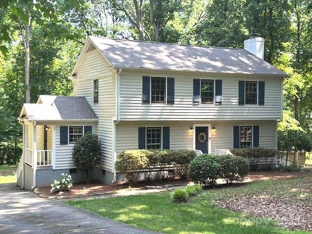 14027 Hackamore Dr, Matthews, NC 28105 - colonial house featuring a chimney, view of scattered trees, and crawl space