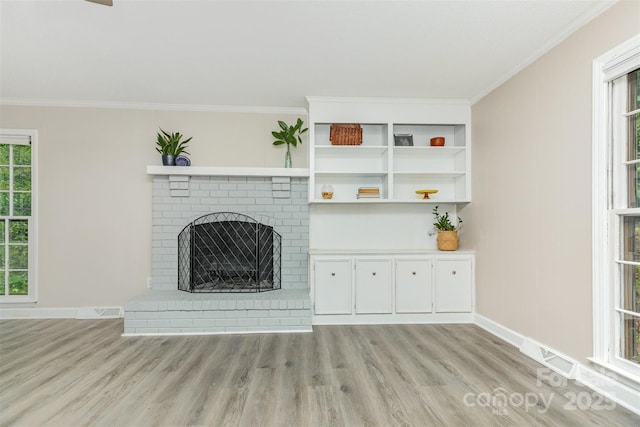 14027 Hackamore Dr, Matthews, NC 28105 - unfurnished living room with light wood-style flooring, crown molding, and a brick fireplace