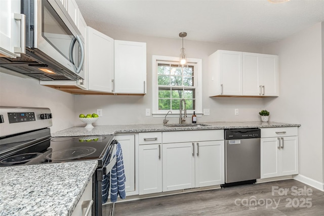 14027 Hackamore Dr, Matthews, NC 28105 - kitchen with appliances with stainless steel finishes, light wood-style floors, white cabinets, and light stone counters