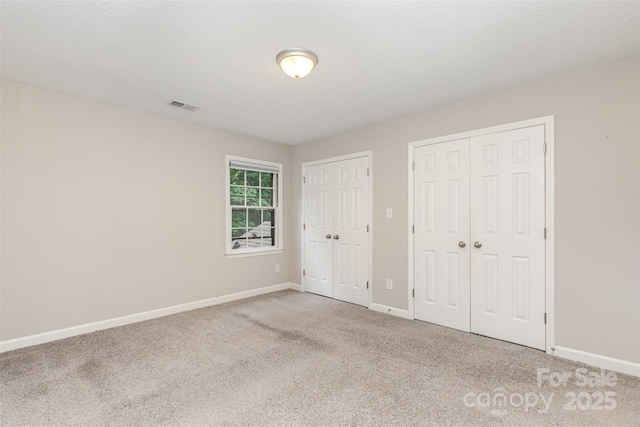 14027 Hackamore Dr, Matthews, NC 28105 - unfurnished bedroom featuring two closets and carpet floors
