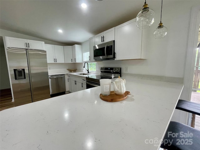 117 Autumn Woods Dr, Kings Mountain, NC 28086 - kitchen featuring appliances with stainless steel finishes, a sink, white cabinets, lofted ceiling, and pendant lighting
