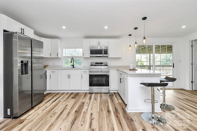 117 Autumn Woods Dr, Kings Mountain, NC 28086 - kitchen featuring stainless steel appliances, a peninsula, light wood-style flooring, light countertops, and white cabinetry