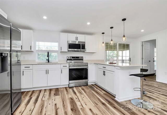 117 Autumn Woods Dr, Kings Mountain, NC 28086 - kitchen featuring appliances with stainless steel finishes, light wood-type flooring, a peninsula, light countertops, and recessed lighting