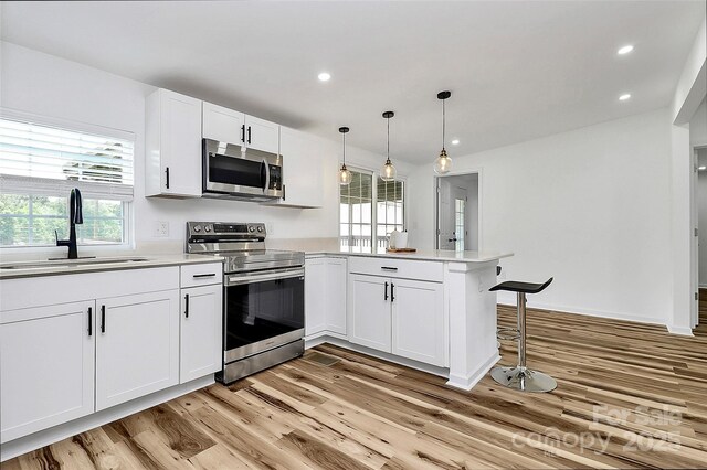 117 Autumn Woods Dr, Kings Mountain, NC 28086 - kitchen featuring appliances with stainless steel finishes, a peninsula, light wood-style floors, white cabinets, and light countertops