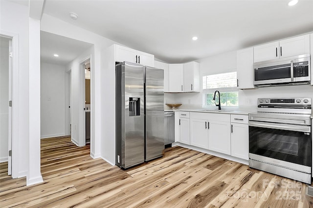 117 Autumn Woods Dr, Kings Mountain, NC 28086 - kitchen with appliances with stainless steel finishes, light wood finished floors, light countertops, white cabinets, and recessed lighting