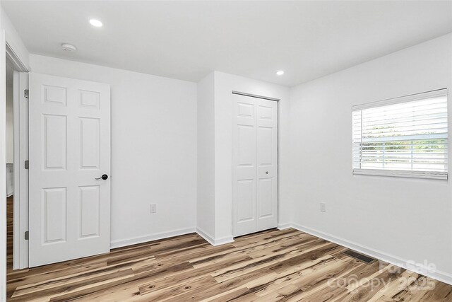 117 Autumn Woods Dr, Kings Mountain, NC 28086 - unfurnished bedroom with light wood finished floors, a closet, and recessed lighting