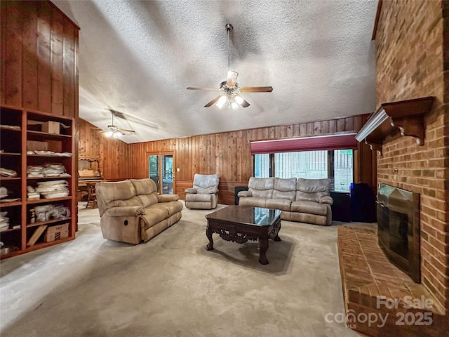 1700 Abbottsford Dr, Kernersville, NC 27284 - living room with ceiling fan, wood walls, carpet flooring, lofted ceiling, and a fireplace