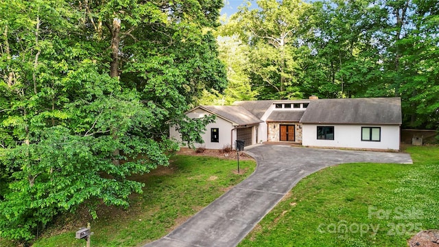 1700 Abbottsford Dr, Kernersville, NC 27284 - view of front of house with an attached garage, asphalt driveway, a front lawn, and a chimney
