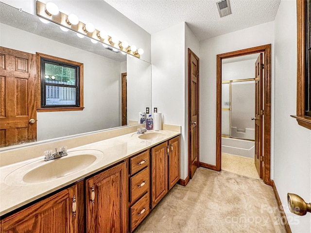 1700 Abbottsford Dr, Kernersville, NC 27284 - full bathroom with double vanity, a textured ceiling, shower / bath combination with glass door, and baseboards