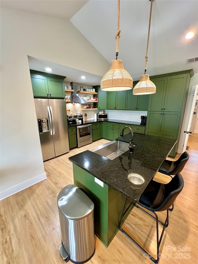 7133 Church Rd, Taylorsville, NC 28681 - kitchen with green cabinetry, appliances with stainless steel finishes, wall chimney range hood, a kitchen breakfast bar, and a sink