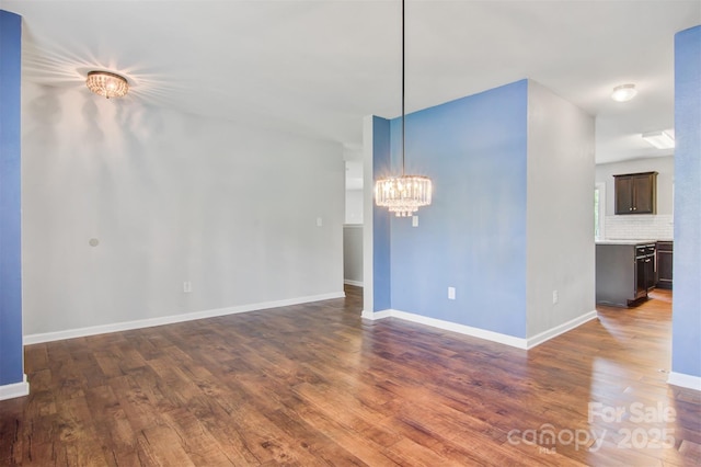 5311 Oakdale Ridge Rd, Charlotte, NC 28216 - unfurnished room featuring dark wood-style floors, a chandelier, and baseboards