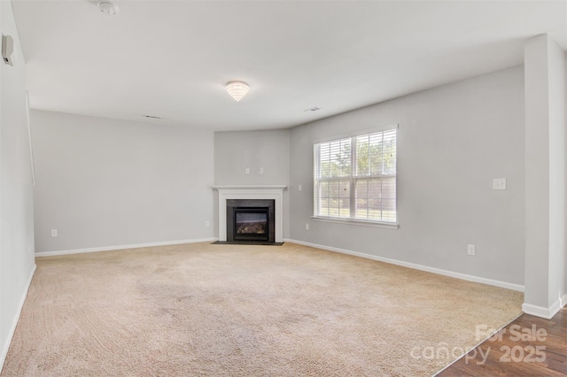 5311 Oakdale Ridge Rd, Charlotte, NC 28216 - unfurnished living room featuring baseboards, a fireplace with flush hearth, and carpet floors