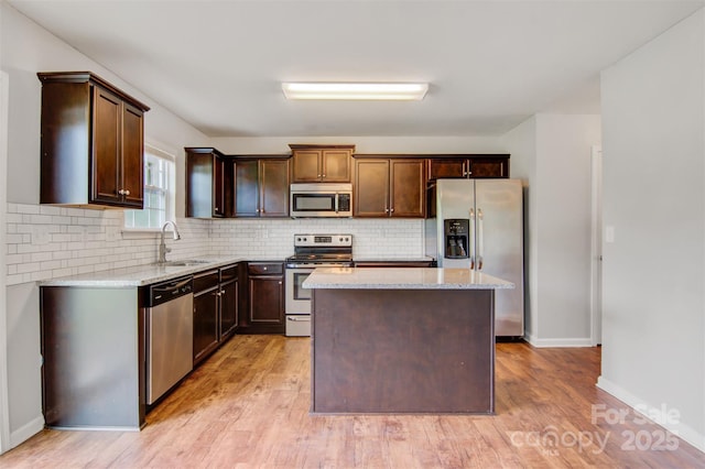 5311 Oakdale Ridge Rd, Charlotte, NC 28216 - kitchen with stainless steel appliances, a sink, light stone countertops, light wood finished floors, and a kitchen island