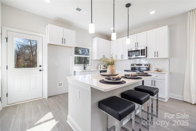 7805 Shadow Lawn Rd, Charlotte, NC 28269 - kitchen featuring appliances with stainless steel finishes, light wood finished floors, light countertops, and recessed lighting