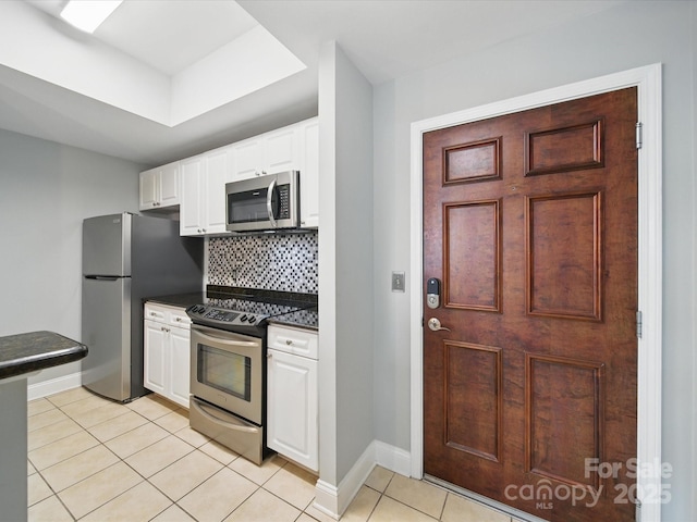 300 W 5th St Unit 339, Charlotte, NC 28202 - kitchen featuring appliances with stainless steel finishes, light tile patterned floors, white cabinetry, and dark countertops