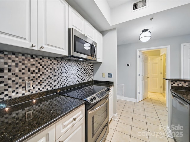 300 W 5th St Unit 339, Charlotte, NC 28202 - kitchen featuring appliances with stainless steel finishes, white cabinets, light tile patterned flooring, tasteful backsplash, and dark stone counters