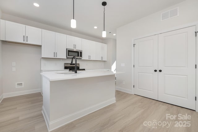 6327 Carver Blvd, Charlotte, NC 28269 - kitchen with stainless steel microwave, light wood finished floors, baseboards, light countertops, and recessed lighting