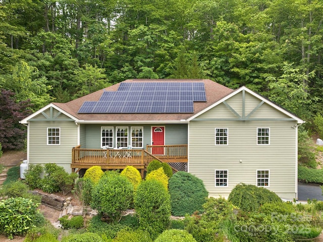 21 Kahluas Way, Fairview, NC 28730 - ranch-style home featuring roof with shingles, solar panels, covered porch, and a forest view