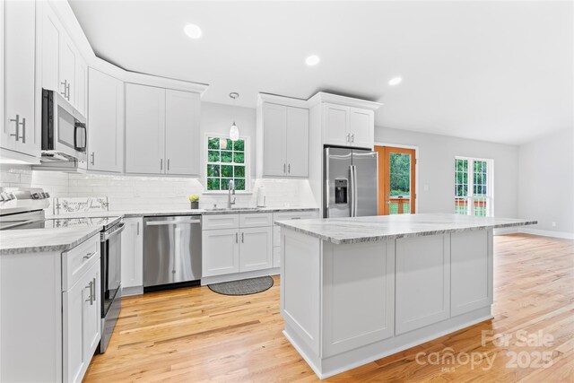 105 Pelican Ct, Mooresville, NC 28117 - kitchen with appliances with stainless steel finishes, a sink, decorative backsplash, white cabinets, and light wood-style floors