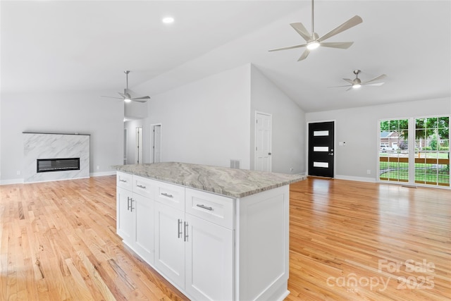 105 Pelican Ct, Mooresville, NC 28117 - kitchen featuring open floor plan, a ceiling fan, light wood finished floors, white cabinetry, and a center island