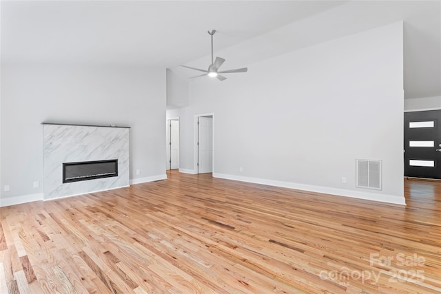 105 Pelican Ct, Mooresville, NC 28117 - unfurnished living room featuring wood finished floors, a ceiling fan, a high end fireplace, baseboards, and high vaulted ceiling