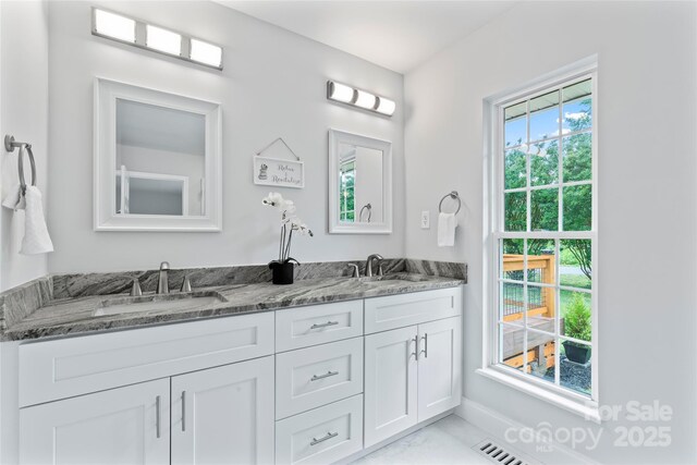 105 Pelican Ct, Mooresville, NC 28117 - bathroom featuring marble look tiles, double vanity, and baseboards