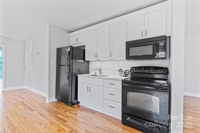 105 Pelican Ct, Mooresville, NC 28117 - kitchen featuring black appliances, a sink, white cabinets, light wood finished floors, and baseboards