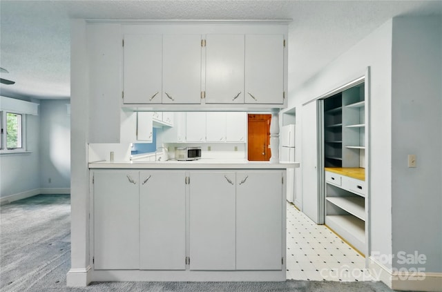 6900 Ridge Lane Rd, Charlotte, NC 28262 - kitchen with a textured ceiling, light countertops, baseboards, a peninsula, and open shelves