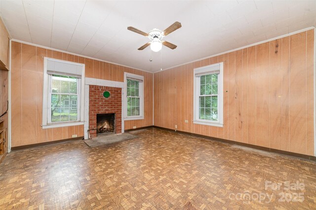 520 Eastwood Park Cir, Albemarle, NC 28001 - unfurnished living room with ornamental molding, ceiling fan, baseboards, wooden walls, and a brick fireplace