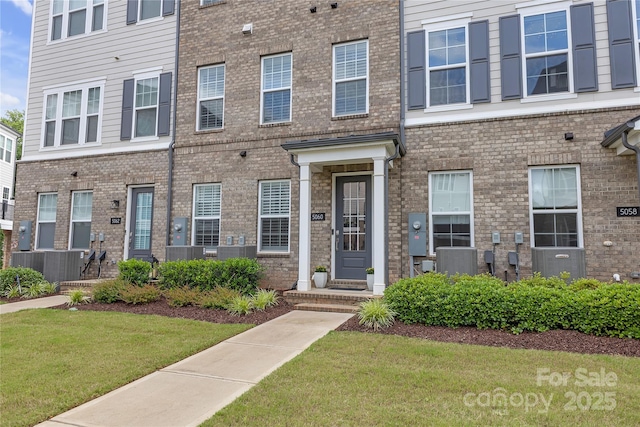 5060 Harrowsmith Ln, Charlotte, NC 28204 - view of front facade with central AC, a front yard, and brick siding