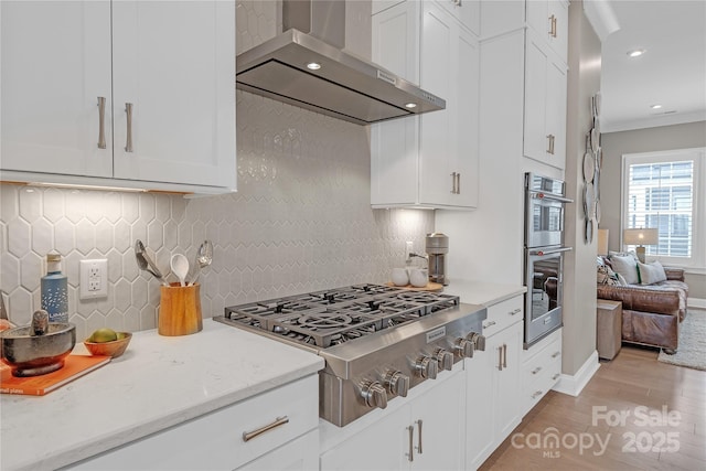 5060 Harrowsmith Ln, Charlotte, NC 28204 - kitchen featuring wall chimney range hood, stainless steel appliances, light wood-type flooring, white cabinets, and recessed lighting