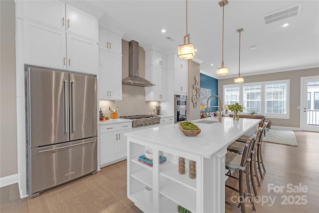 5060 Harrowsmith Ln, Charlotte, NC 28204 - kitchen featuring appliances with stainless steel finishes, wall chimney exhaust hood, a sink, light wood finished floors, and light countertops