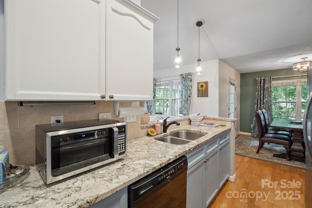 119 Ashwood Ln, Mooresville, NC 28117 - kitchen with dishwasher, light wood-type flooring, stainless steel microwave, light stone counters, and hanging light fixtures