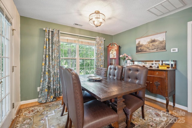 119 Ashwood Ln, Mooresville, NC 28117 - dining room with wood finished floors, a textured ceiling, and a chandelier