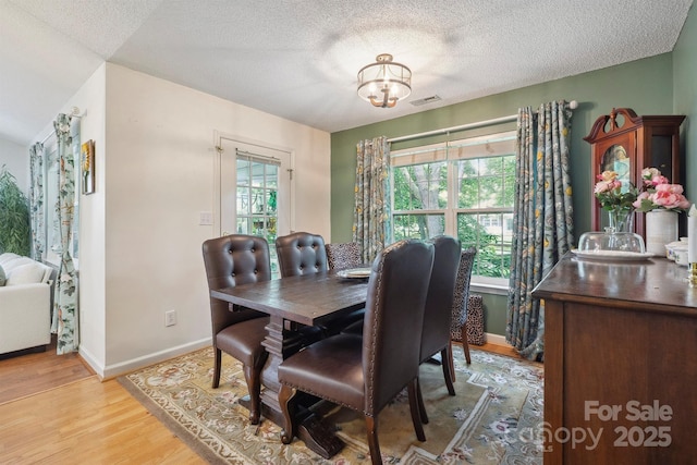 119 Ashwood Ln, Mooresville, NC 28117 - dining space featuring light wood-style floors, a textured ceiling, and a chandelier