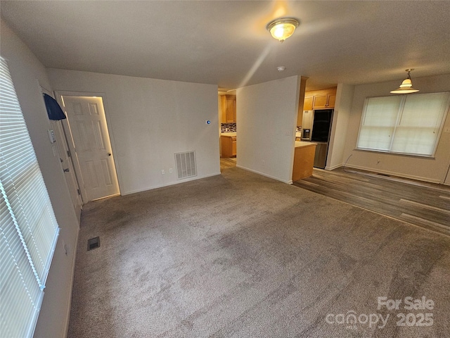 606 N St, Belmont, NC 28012 - unfurnished living room featuring dark carpet and baseboards