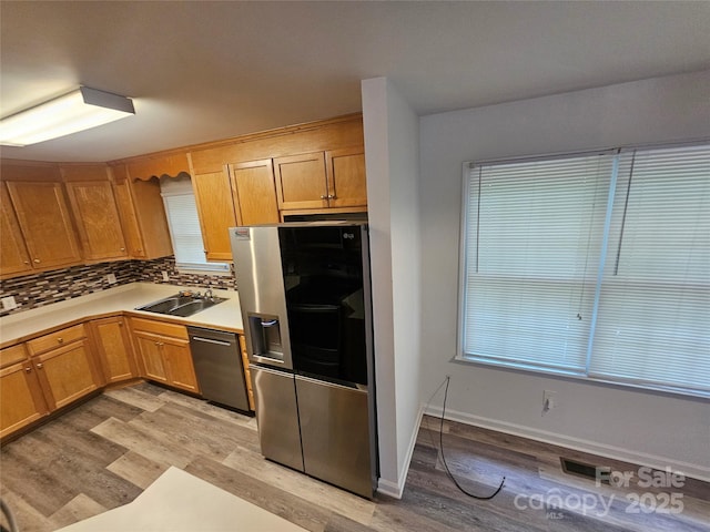 606 N St, Belmont, NC 28012 - kitchen with appliances with stainless steel finishes, light wood-style flooring, backsplash, and light countertops