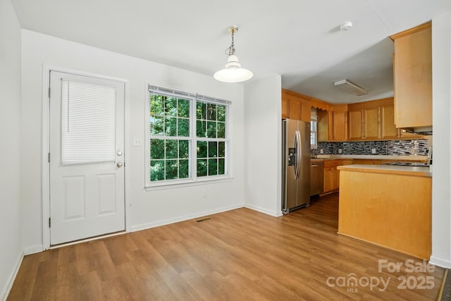 606 N St, Belmont, NC 28012 - kitchen featuring appliances with stainless steel finishes, wood finished floors, decorative backsplash, and light countertops