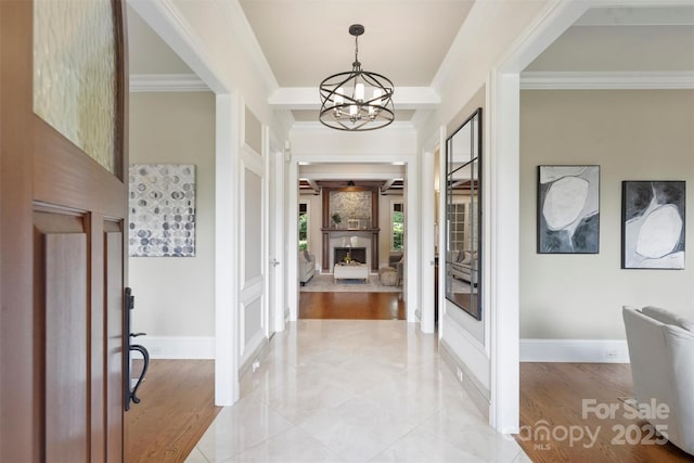 3032 Kings Manor Dr, Matthews, NC 28104 - foyer entrance with crown molding, a chandelier, a large fireplace, and light wood-style flooring