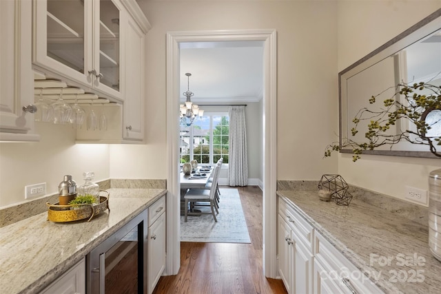 3032 Kings Manor Dr, Matthews, NC 28104 - bar area with wine cooler, dark wood-type flooring, a chandelier, and crown molding